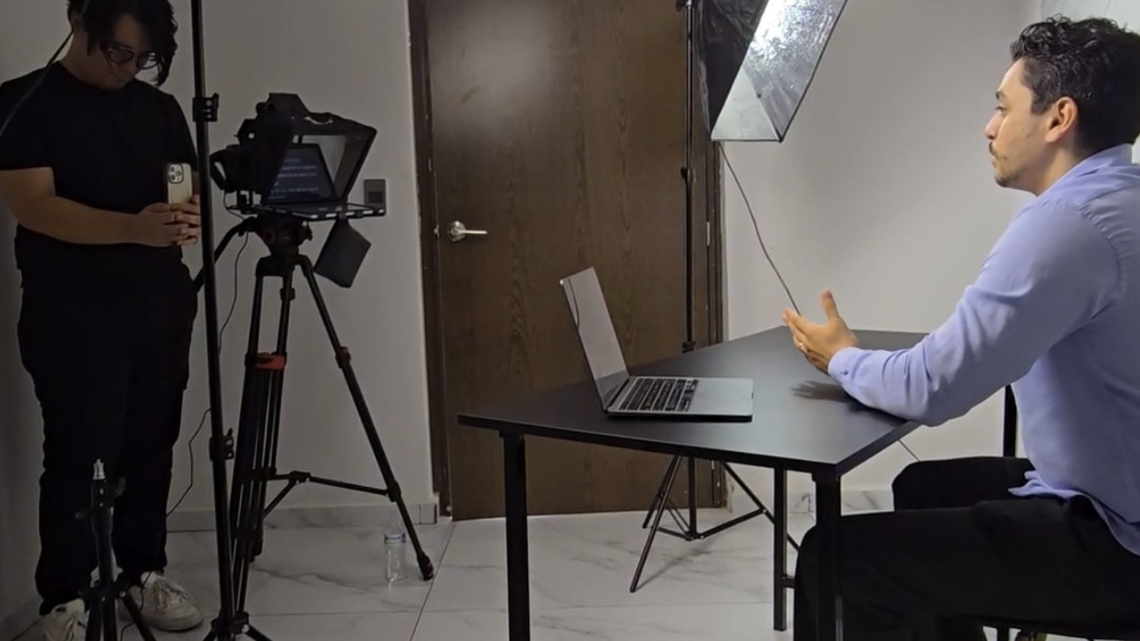 Sesión de grabación real: teleprompter con guion en pantalla, softbox y especialista frente a cámara