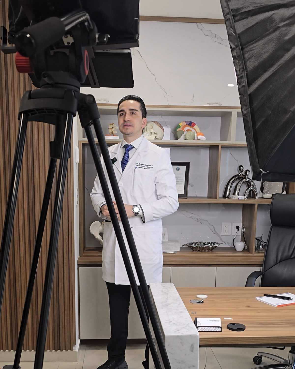Especialista grabando frente a cámara y teleprompter en su consultorio